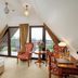 Hotel Paryski Art & Business attic room in Zakopane with balcony doors, floral chairs and work desk