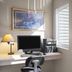 Super 8 by Wyndham Lewistown guest room with desk, TV, lamp, and windows overlooking greenery and a flag.