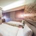 Military 75 Hotel, Taichung City guest room with two beds, wall-mounted TV, and brick accent wall