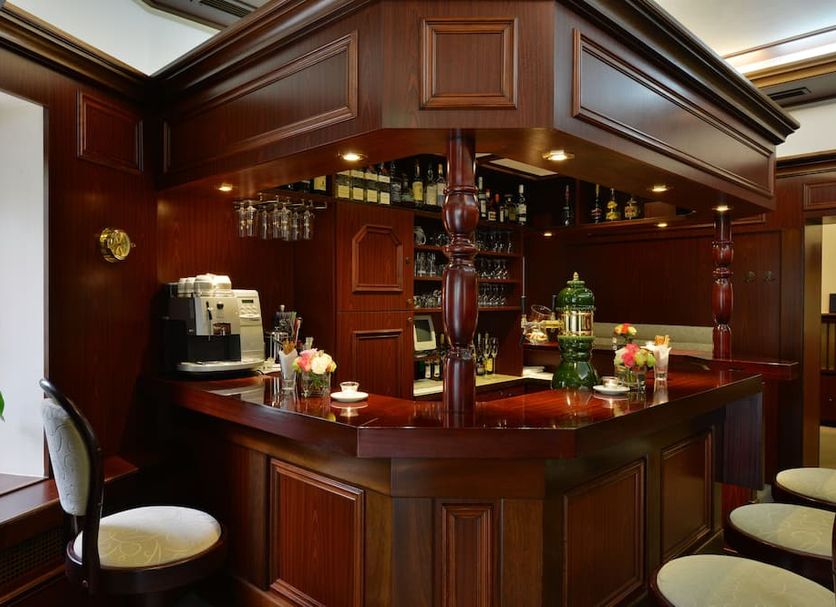 Hotel Imperial in Cologne bar area with polished wood counter, stools, glassware and floral decor