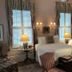 1842 Inn in Macon guest room with twin beds, lamps, patterned chairs, and tall windows