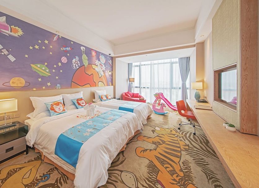 Best Boutique Hotel Shanghai guest room with colorful space mural, twin beds, and kids’ play area