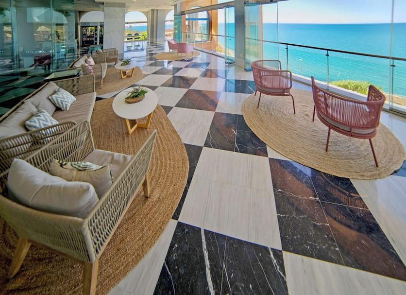 Casamaia Apartments Affiliated by Melia in Benalmádena lounge with sea-view windows and wicker seating