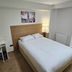 Homefield Lodge London bedroom with double bed, desk, kettle, and bedside lamp