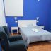 The Dreamers&Co in Córdoba: simple guest room with bed, armchairs, and blue accent wall
