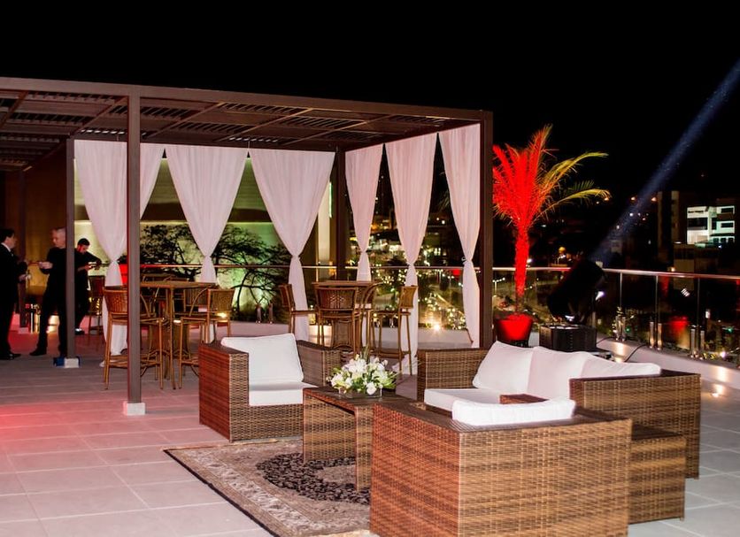 ibis Jundiai Shopping rooftop lounge with wicker seating, canopy curtains and city lights in Jundiaí