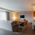 Hilton Garden Inn Sioux Falls Downtown suite with living area, kitchenette bar, and wall-mounted TV