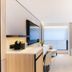 The Bauhinia Hotel - Central room with sofa, desk, and city view windows in Hong Kong