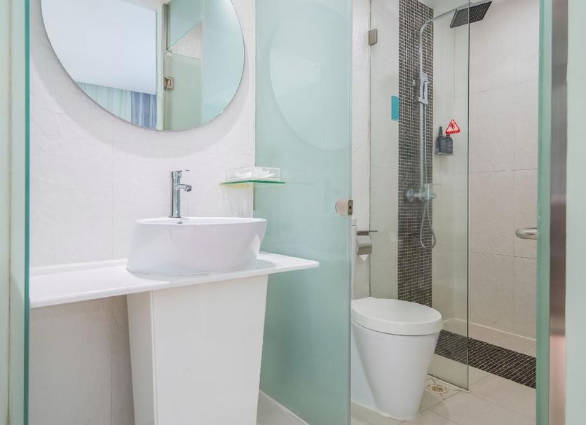Shanshui Trends Luohu Hotel in Shenzhen bathroom with vessel sink, round mirror and glass shower