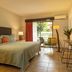 Natural Lodge Caño Negro guest room with king bed, balcony door, and seating area in Caño Negro