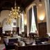 Danesfield House Hotel And Spa in Marlow: grand lounge with chandeliers, fireplace and tall arched windows