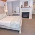 Inn On Peaks Island guest room with a king bed, bedside tables, fireplace and vanity area in Peaks Island