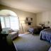 4 Seasons at Desert Breezes Palm Desert guest room with two beds, lounge chair and arched window
