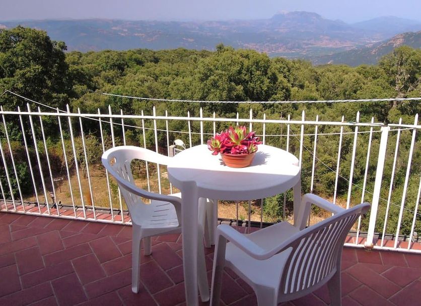 Casa Solotti in Nuoro: balcony with white table and chairs overlooking mountains and greenery