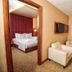 Adana Garden Business Hotel in Adana, suite with bedroom, sitting area, sofa, armchairs and TV
