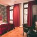 Hotel Villa Klemm - Wiesbaden City room with red bedspread, tall windows and zebra-print accent wall