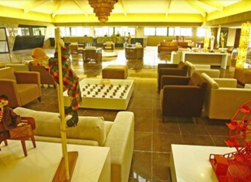 Garden Hotel in Campina Grande lounge with sofas, tables and a red decorative wheel display