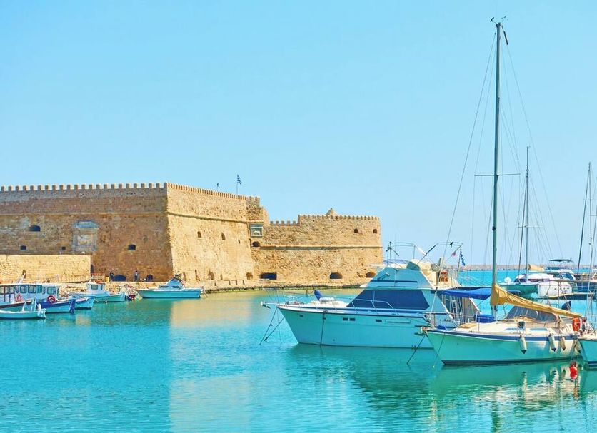City Life Port Hotel in Heraklion, harbor view with sailboats and turquoise water beside a stone seawall
