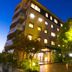Hotel Matsukaze in Toyota, exterior at night with lit windows, entrance, and landscaped greenery