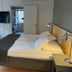 Linköpings Cityhotell och Vandrarhem guest room with bed, wall-mounted TV and chair in Linköping