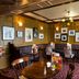 Premier Inn Milton Keynes South in Milton Keynes dining area with tables, chairs, framed wall art, and booth seating