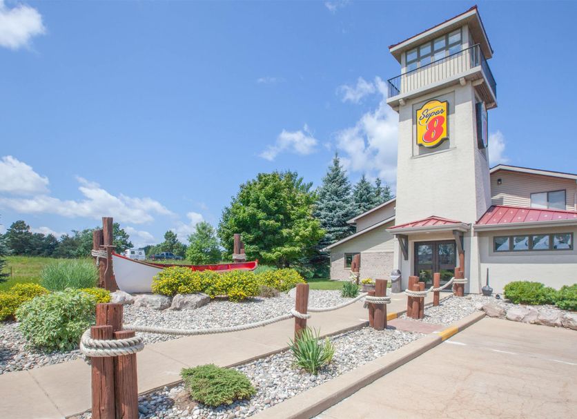 Super 8 by Wyndham Houghton Lake exterior with tower entrance and landscaped grounds