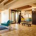 First Group Riviera Suites in Cape Town lobby with teal chairs, yellow sofa, and luggage cart near entrance