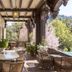 Benbow Historic Inn in Garberville with a covered veranda, wicker seating, and forest views