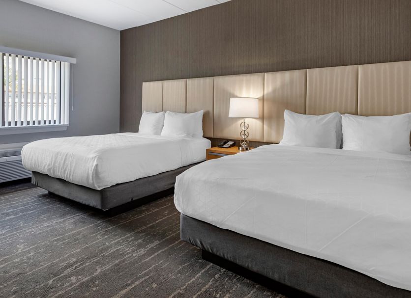 Amwell Suites in South Bound Brook room with two queen beds, headboard lighting, and window blinds
