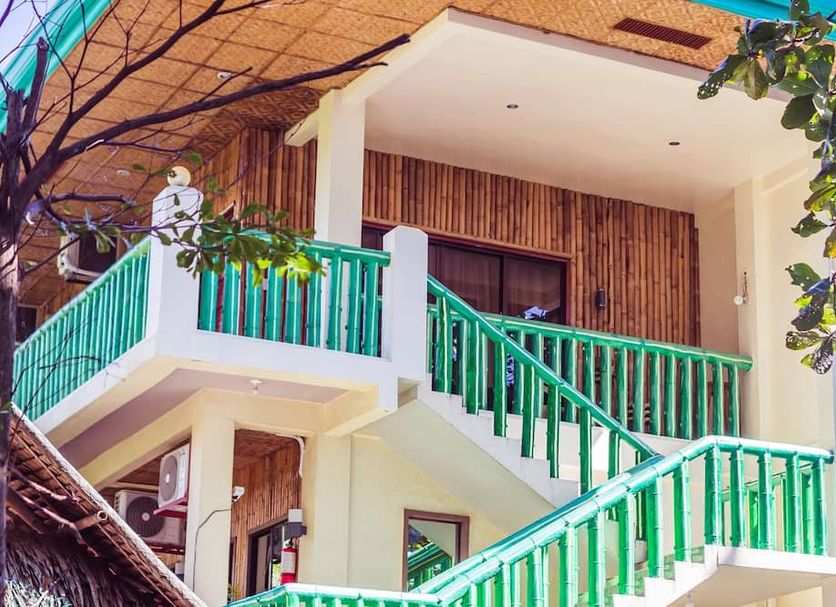 Ceazar's Place in Dauin with a tropical balcony, green railings, and stairway exterior