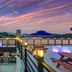 Onda D'oro Hostel in Yeosu rooftop terrace with sea view, lit lanterns, and picnic tables at sunset