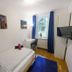 Basement Rotherbaum Hamburg room with single bed, desk by window, wall-mounted TV and blue rug