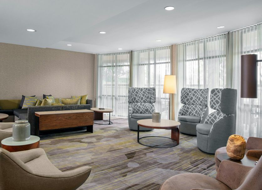 Courtyard by Marriott Jacksonville I-295/East Beltway lounge with chairs, sofa and large windows in Jacksonville