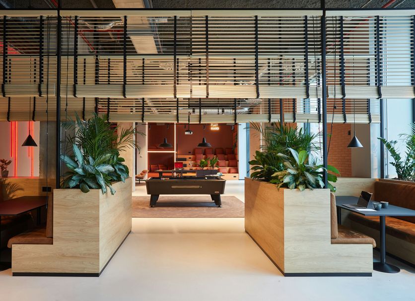 The Social Hub Barcelona Poblenou lobby with pool table, seating, and tall planters in Barcelona