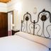 Agriturismo Villa La Morina bedroom in Cortona with wrought-iron headboard and bathroom doorway