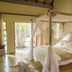 La Lechere Guest House in Phalaborwa: canopy bed in airy guest room with outdoor garden view