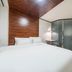 Hotel Atti Incheon guest room with double bed, wood accent wall and glass shower enclosure