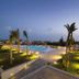 I Giardini della Castellana in Marina di Ragusa with illuminated rooftop pool and sea view at dusk