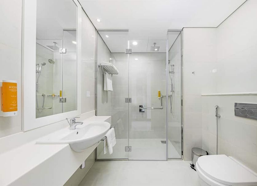 Citymax Hotel Business Bay bathroom in Dubai with glass shower, vanity sink, and toilet