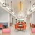 Embassy Suites by Hilton Tampa Airport Westshore dining area in Tampa with orange chairs and high ceiling