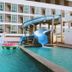 Glory Place Hua Hin hotel pool with blue waterslide and unicorn float in front of the building