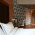 Amadi Park Hotel Amsterdam guest room with bed, desk, patterned wallpaper, and open bathroom area