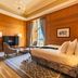 Pousada de Lisboa luxury suite with wood-paneled walls, king bed, seating area and city view in Lisbon