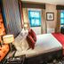 The Torrance Hotel Glasgow guest room with king bed, desk, sofa, TV and patterned carpet