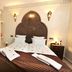 Riad Belle Epoque, Marrakech: ornate bedroom with arched headboard, twin beds and bedside lamps