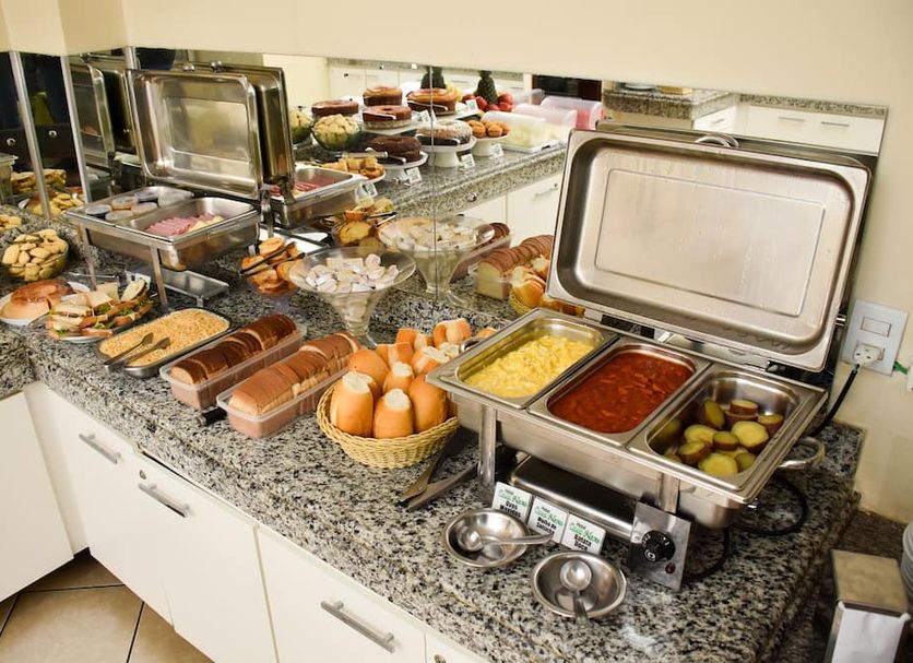 Hotel Casa Nova in Várzea Grande breakfast buffet with eggs, sausages, pastries, and hot dishes