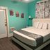 Americas Best Value Inn & Suites Royal Carriage room in Jamestown with bed, teal walls and patterned curtains