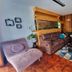 Casa Jardin Del Mango San José lounge with sofas, coffee table, and wood-paneled wall