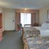 Vagabond Inn Ventura guest room with two beds, TV, desk, and window view in Ventura