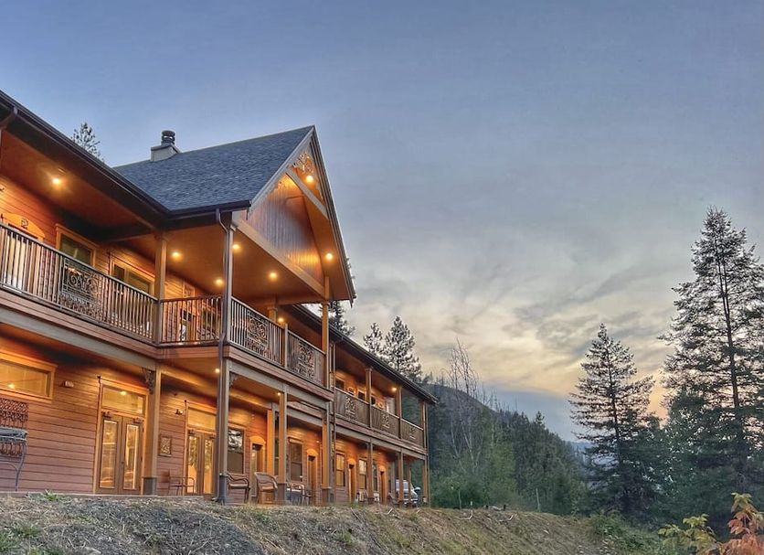 Hearthstone Elegant Lodge by the River in Kamiah, lodge exterior at dusk with mountain and tree views